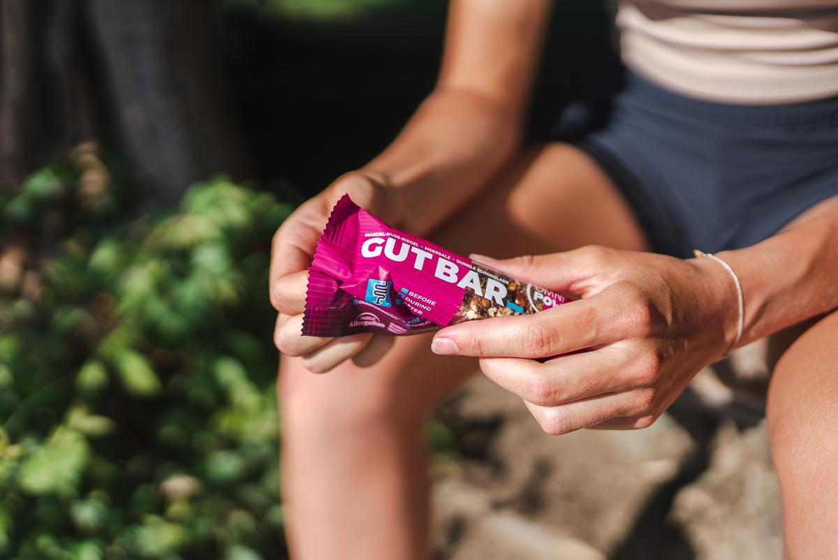 OMNi-POWER Snack Riegel, Sport Riegel, Gut Bar gehalten in Hand von Person auf Parkbank 